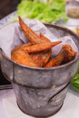 Fried chicken wings in bucket on Dining table