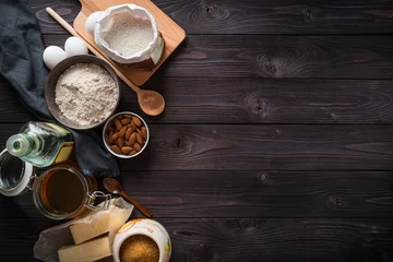 Fotobehang Ingrediënten voor het bakken op een houten bovenaanzicht als achtergrond © Alexander Gogolin