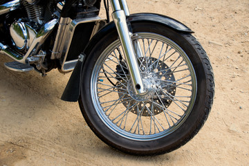 Close up front wheel motorcycle chopper  on the floor.