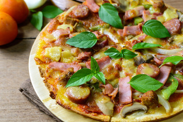 Rustic pizza with becon, salami, mozzarella and basil