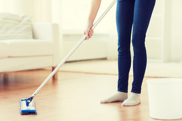 close up of woman with mop cleaning floor at home