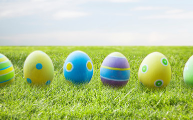 close up of colored easter eggs on wooden surface