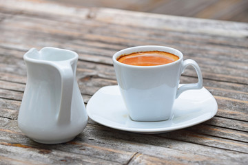 One full cup of espresso coffee on bamboo table