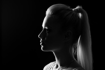 Woman portrait silhuette in darkness with soft light on face.