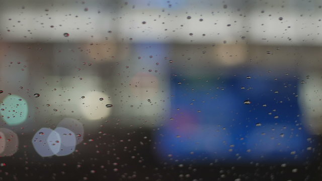 Raindrops on the window and defocused signs and street illumination at the airport.