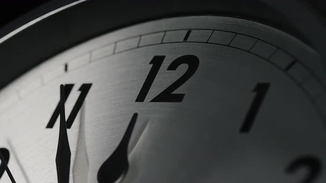 Slow zoom into a clock face as 12 o'clock approaches, 11:55