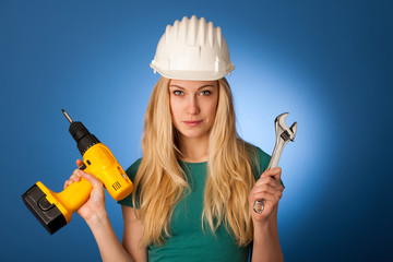 Woman with constructor helmet and tools happy to do tough work.