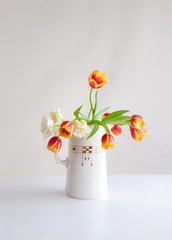 Colorful bouquet of tulips in vintage pitcher.
