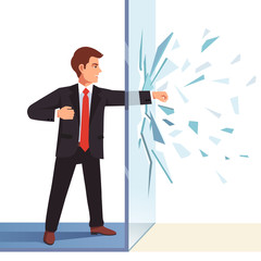 Businessman breaking through invisible glass wall