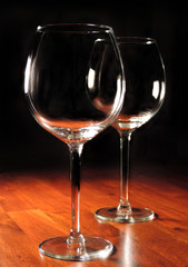 wine glasses on a wooden table, black background
