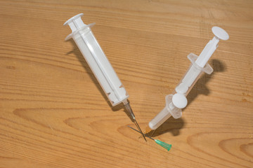 pocketed needles, syringes on a wooden background,