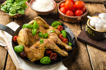 Chicken baked with tomatoes and basil on iron pan