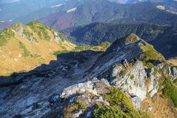 Fototapeta na wymiar two hikers sitting on high mounain peak, aerial view