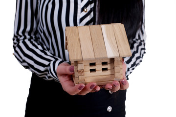 holding house representing home ownership and the Real Estate business