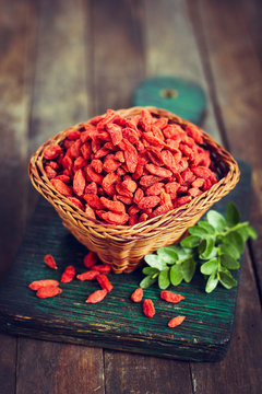 Goji berries in the basket on the rustic table
