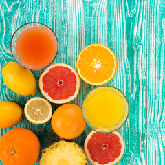 fresh juice from citrus fruits - lemon, grapefruit, orange, pine apple in glasses on  turquoise colored wooden background, top view. copy space, free space for your text. - 104312287