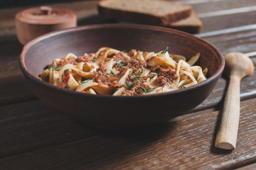 pasta tagliatelle bolgnese on the wooden table, rustic style