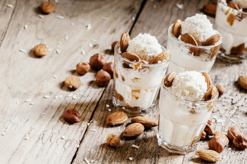 Dessert with vanilla ice cream, nut sauce, almonds, hazelnuts an