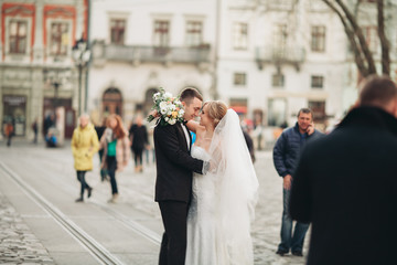 wedding couple is standing and kissing in the streets of old city