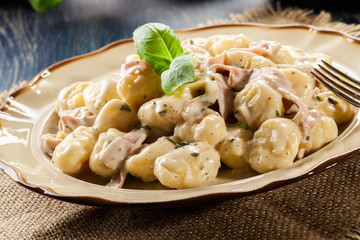 Potato gnocchi, Italian potato dumplings with cheese sauce, ham