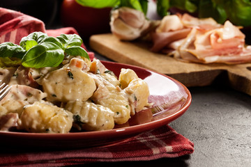 Potato gnocchi, Italian potato dumplings with cheese sauce, ham