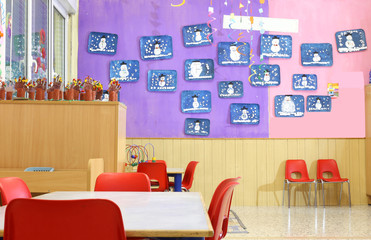 kindergarten class with small red chairs and children's drawings