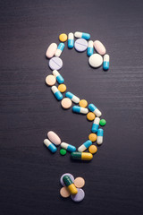 Pharmacy background on a black table.Question. question mark. Tablets on a black background. Pills. Medicine and healthy. Close up of capsules. Differend kind of pills 