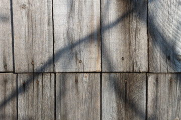 The shadow on the fence of twigs.