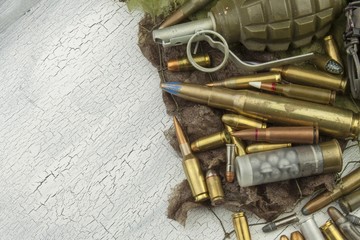 Different types of ammunition on a camouflage background. Preparing for war. Possession of...