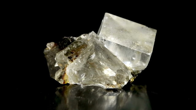 Cubic fluorite (CaF2) crystal rotation isolated on black background
