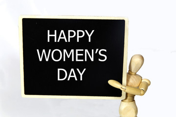 happy women's day writes on the blackboard in the hands of wooden persona. isolated on white background