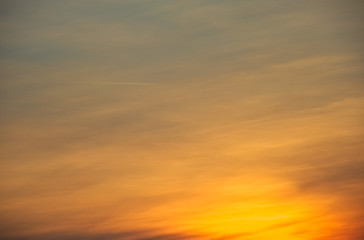 Obraz premium Leicht bewölkter warmer Sonnenuntergang mit orangem Licht