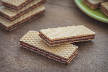 Wafers with chocolate on wooden table