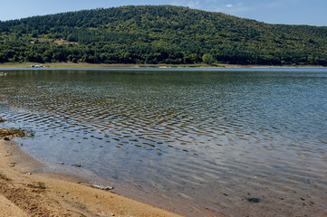 Picturesque Rabisha  lake  with authentic shore, bivouac  and mountain over Magura cave, Belogradchik, Bulgaria