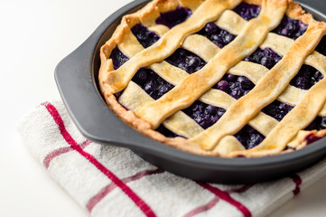 Homemade blueberry pie cooling off in a baking pan, viewed from above.
