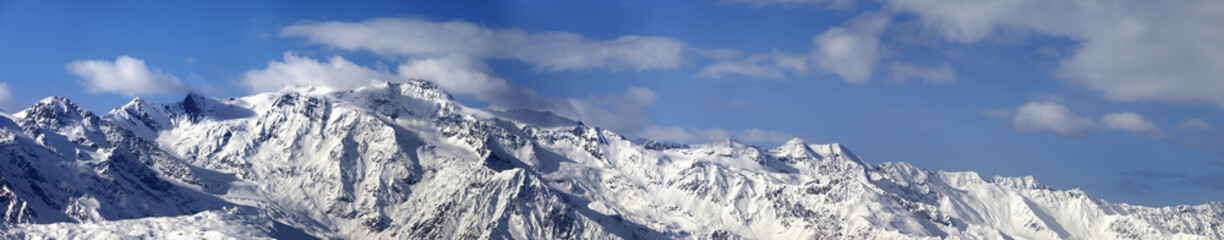 Large panoramic view on snowy mountains in nice sunny day