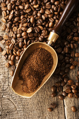 ground coffee in scoop and coffee beans on a wooden background