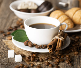 Hot coffee and pastries on a wooden background