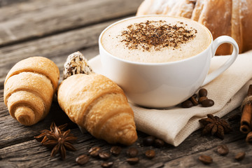 Hot coffee and pastries on a wooden background