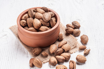 Almond nuts in bowl rustic wooden background
