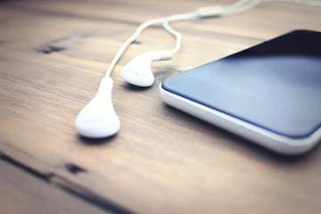 earphone and phone on wooden table