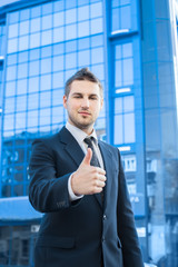 Businessman showing OK sign with his thumb up.