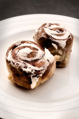 Closeup of two cinnamon buns on a white plate