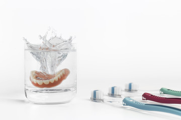 Dentures concept with glass, mask and toothbrush