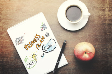 paper, pen, coffee and apple on table