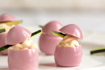 deviled quail eggs with cream cheese, dyed with beet juice.