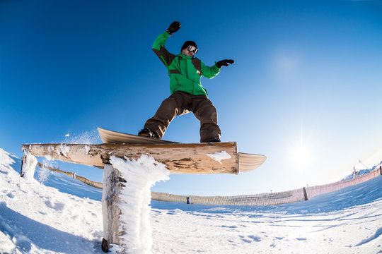 Snowboarder sliding on a rail