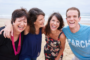 Obraz premium Family laughing and having fun on the beach together