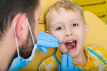 Close up of boy having his teeth examined by a dentist