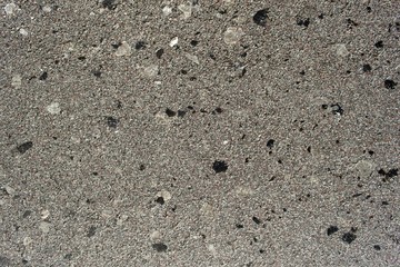 Grey concrete slab with stone inclusions background